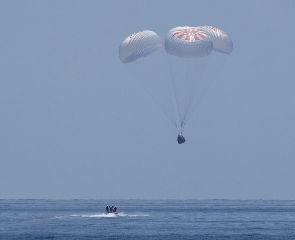 The SpaceX Crew Dragon Endeavour spacecraft is seen as it lands with NASA astronauts Robert Behnken and Douglas Hurley onboard in the Gulf of Mexico off the coast of Pensacola, Florida, Sunday, Aug. 2, 2020. The Demo-2 test flight for NASA's Commercial Crew Program was the first to deliver astronauts to the International Space Station and return them safely to Earth onboard a commercially built and operated spacecraft. Behnken and Hurley returned after spending 64 days in space. Photo Credit: (NASA/Bill Ingalls)