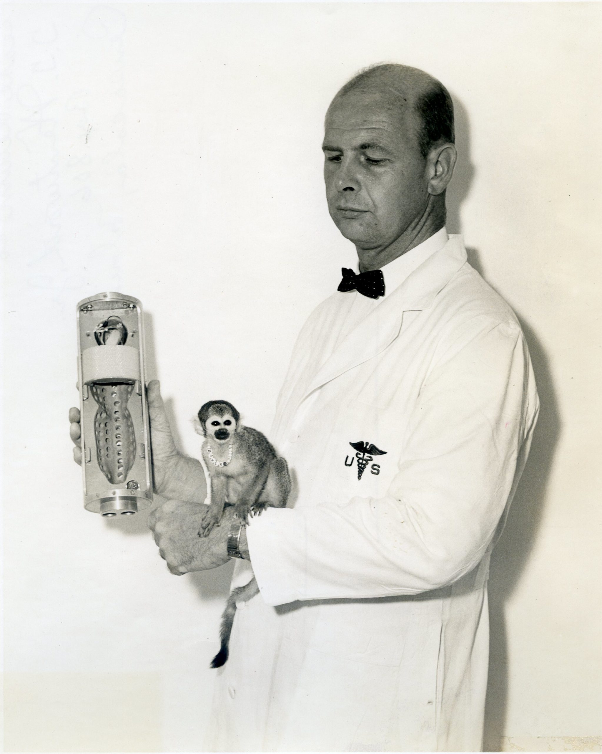 Miss Baker Dr. Donald E. Stullken holding space capsule that monkey Baker made her space trip in;